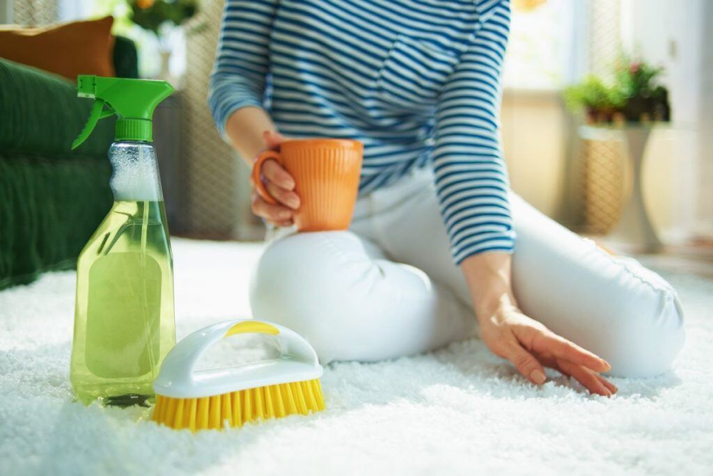 woman on the floor doing essential oil diffuser to to get smoke smell out of her carpet