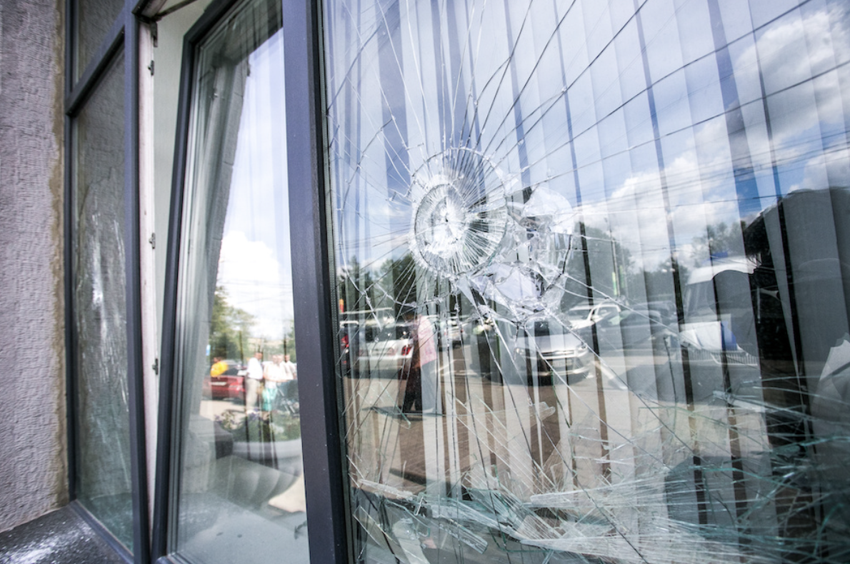 A smashed window on a property in need of vandalism cleanup.