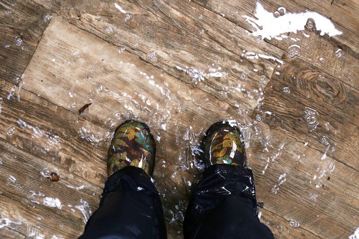 A person's legs in boots during a flood