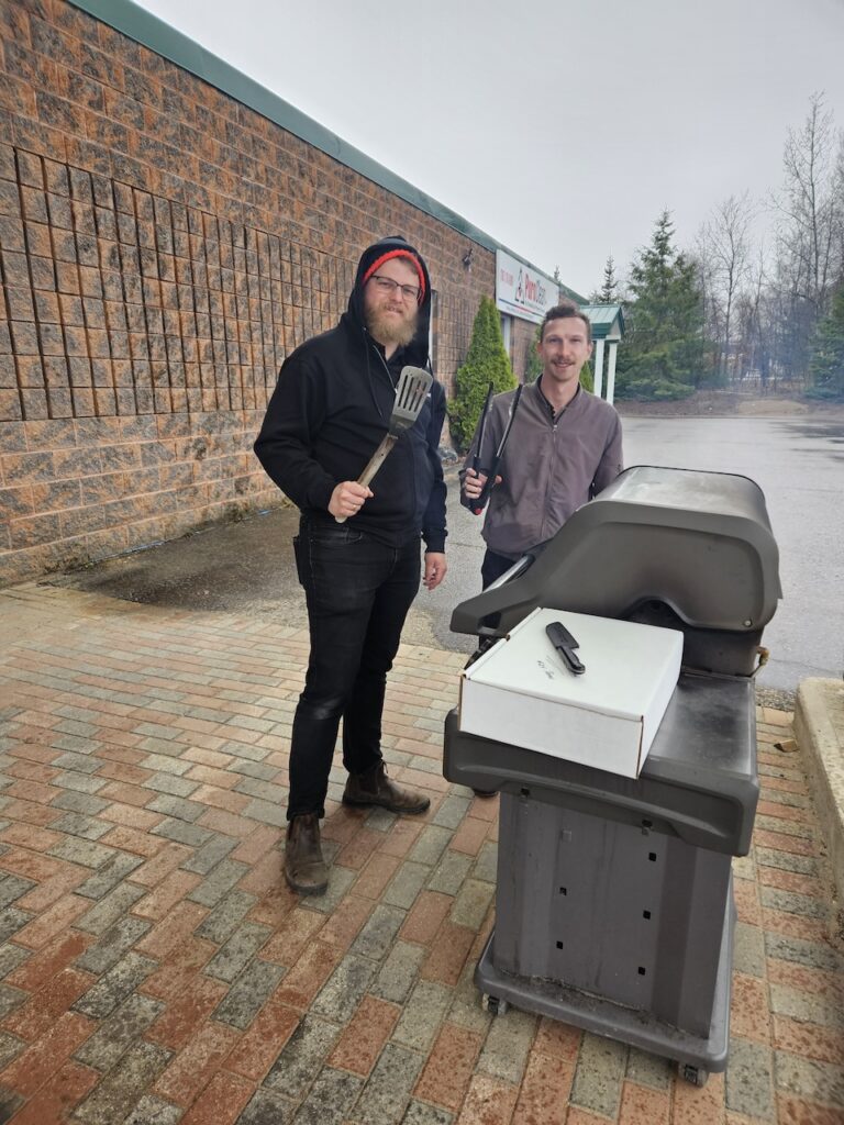 Two members of the PuroClean team grilled hotdogs and burgers after completing the CEC in "Biohazard Basics."