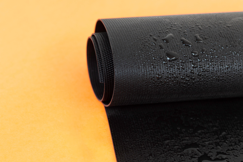 Water droplets on a rubber moisture barrier roll.